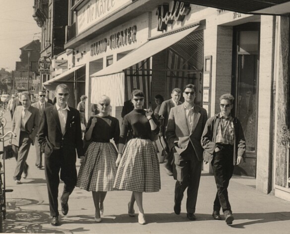 Fünf Jugendliche auf Klassenfahrt, sie flanieren an Geschäften vorbei