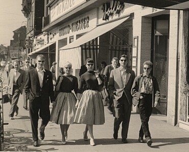 Fünf Jugendliche auf Klassenfahrt, sie flanieren an Geschäften vorbei